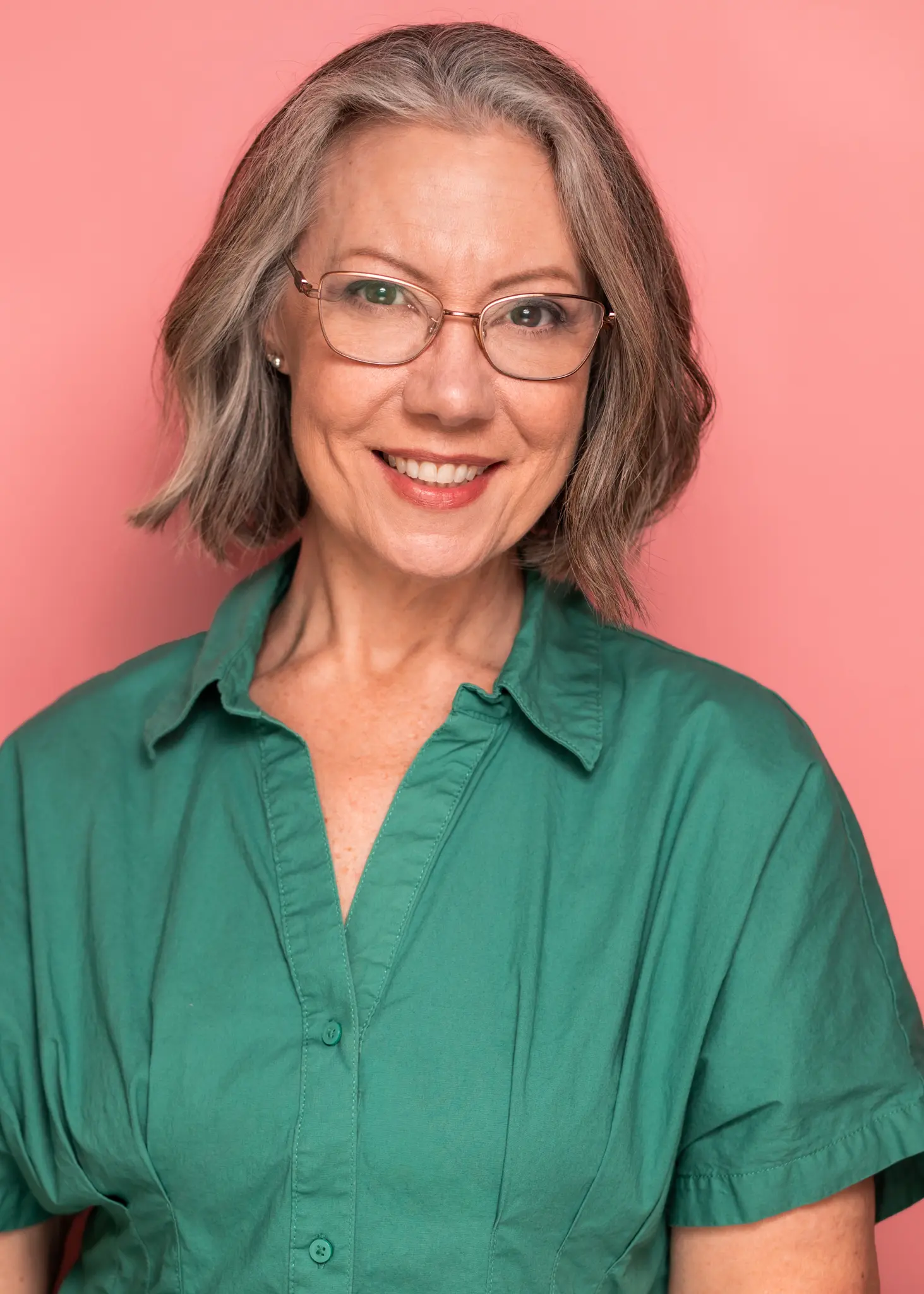 Headshot with green shirt and pink background